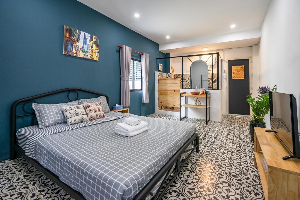 胡志明市西贡霍罗通话度假屋 - 服务式民宿的一间卧室配有一张蓝色墙壁的床