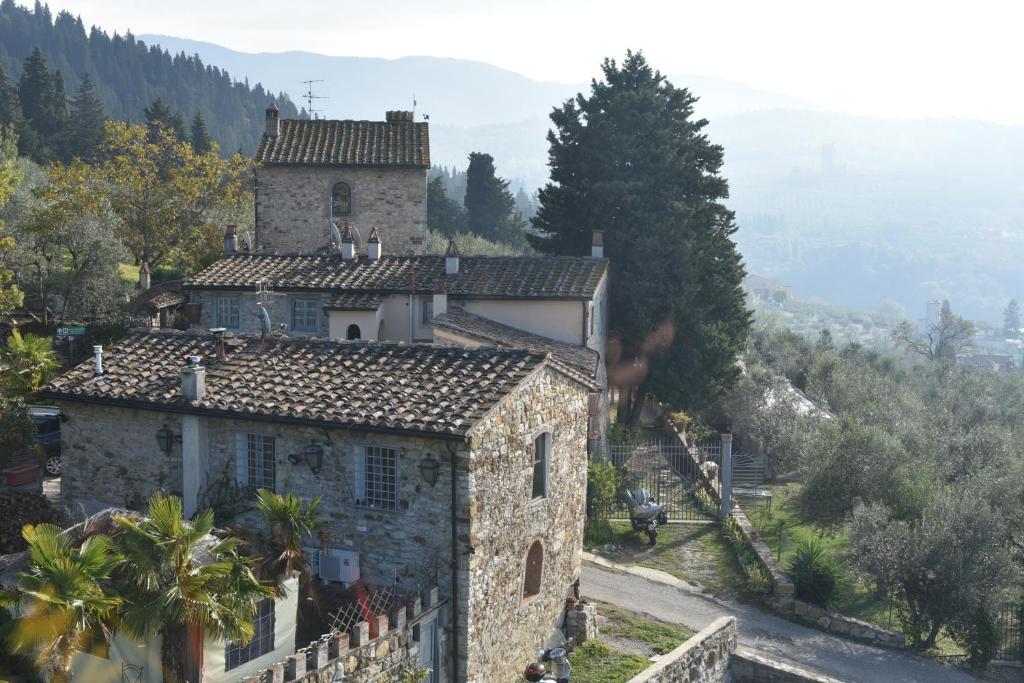 卡莱扎诺Poggio Alla Pieve Relais的一座位于山上的古老石屋,享有美景