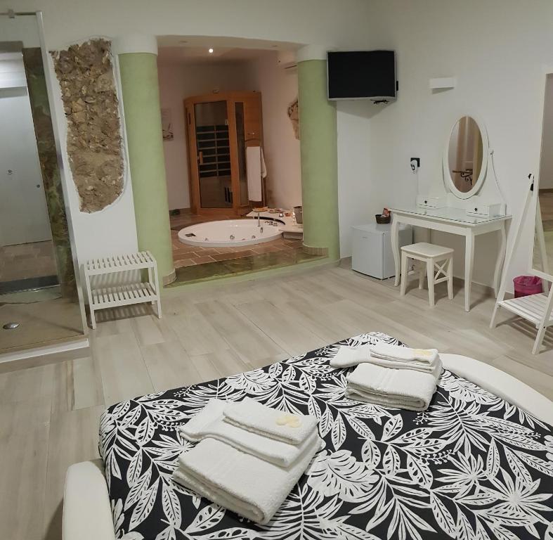 锡拉库扎Il Daviduccio Suite的一间卧室配有一张大床和毛巾