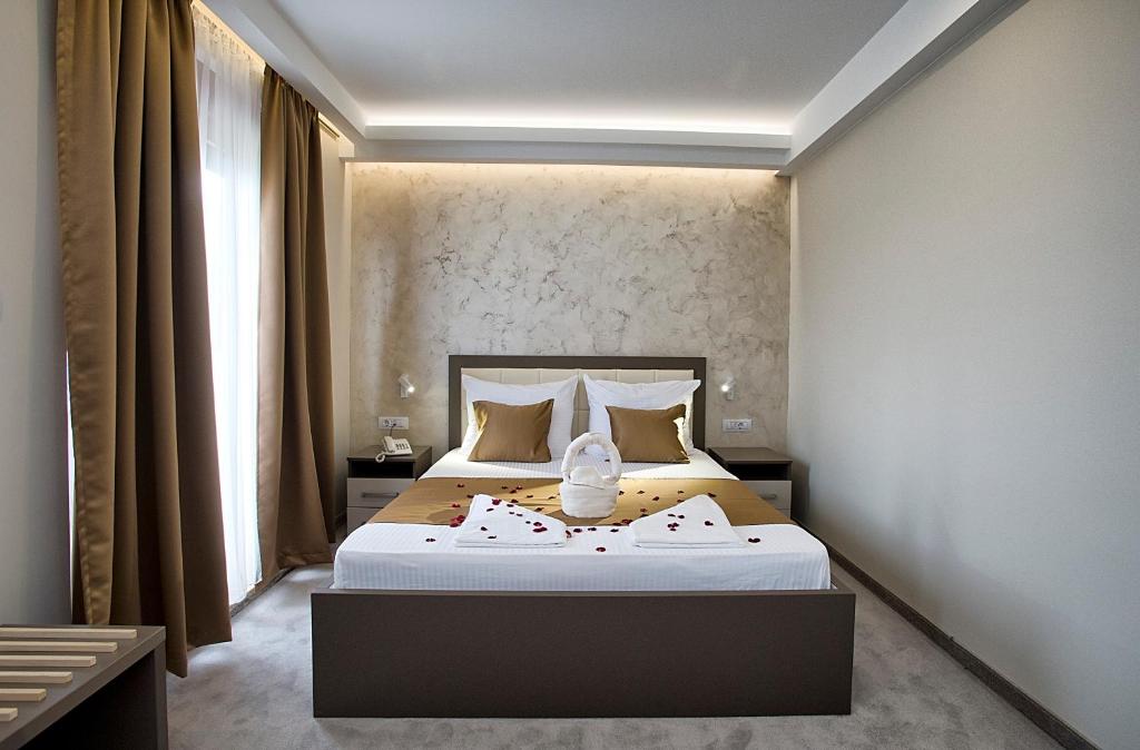 波德戈里察Hotel Fobra的一间卧室,卧室内配有一张大床