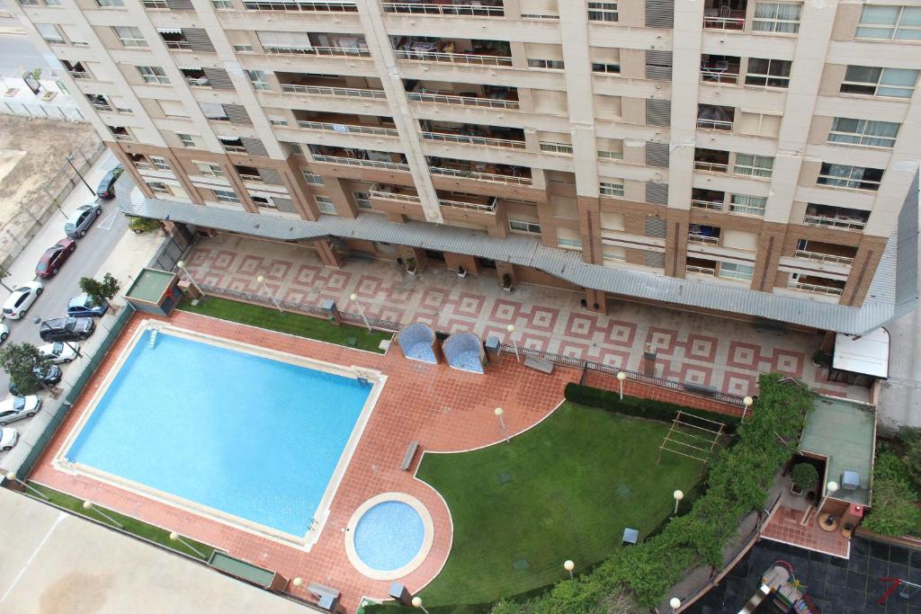 瓦伦西亚Oceanográfico Apartments的享有带游泳池的大型建筑的顶部景色
