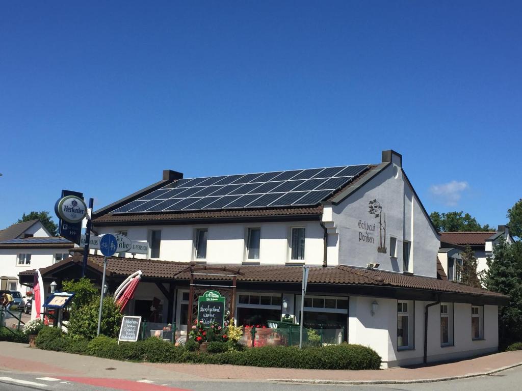 格洛韦Gasthaus & Pension "Zur Schaabe"的屋顶上设有太阳能电池板的建筑