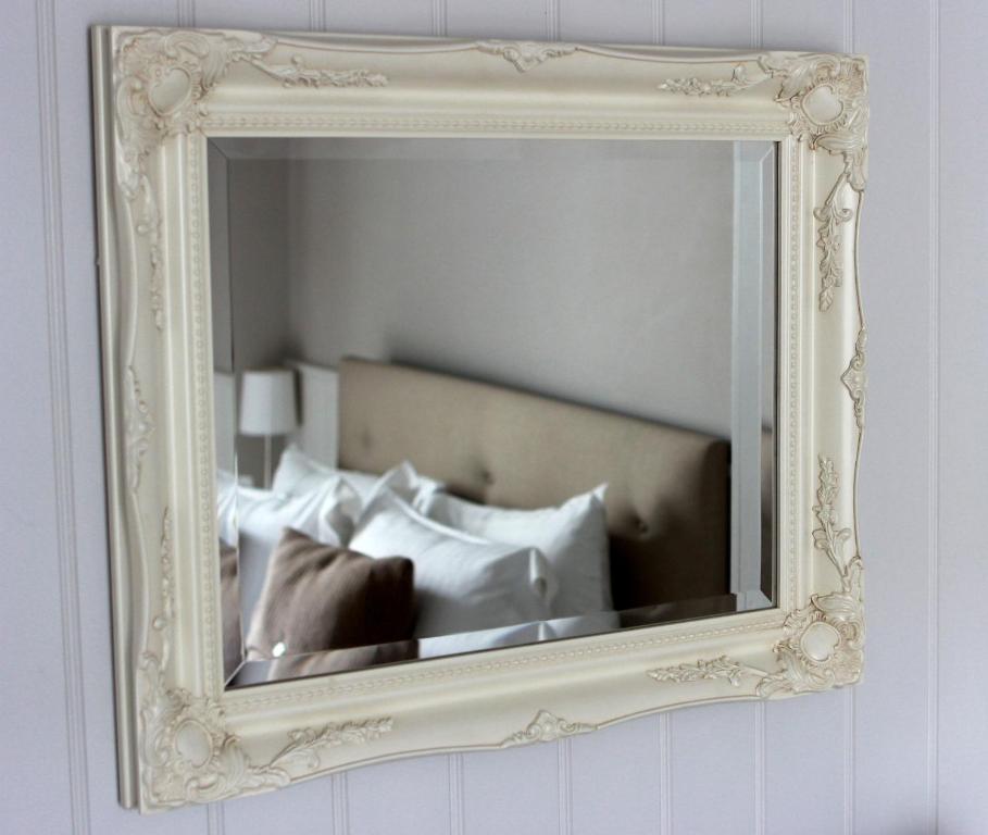 伦敦华克斯昂酒店的墙上的镜子,床上配有枕头