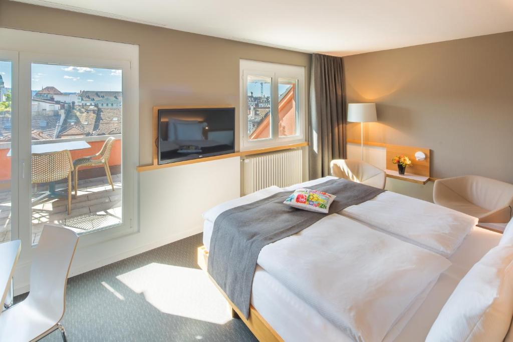 苏黎世祖尔赫霍夫贝斯特韦斯特PLUS酒店的酒店客房设有一张床和一个阳台。