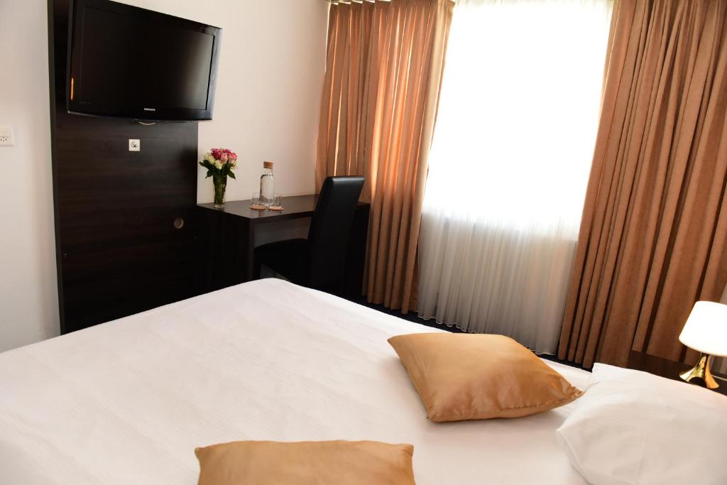温特图尔托斯酒店的酒店客房设有一张床铺,墙上配有电视