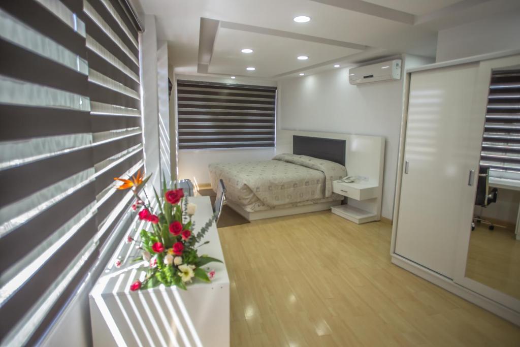科恰班巴里贾纳公寓酒店的一间卧室设有一张床和一个鲜花窗口