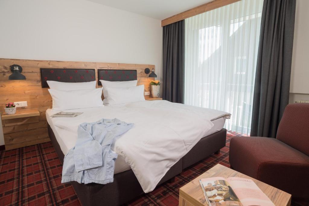 黑林山区圣格奥尔根卡默勒酒店的酒店客房带一张大床和一把椅子