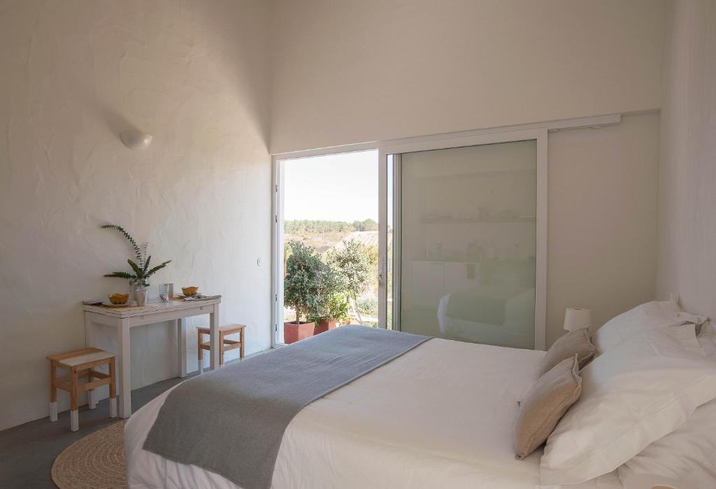 奥德赛克斯Alma Cheia Sunrise Studio Apartment的卧室设有一张白色大床和一扇窗户。
