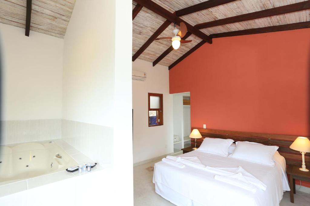 伊利亚贝拉Chalés Mariolinha的一间卧室设有一张大床和一个浴缸