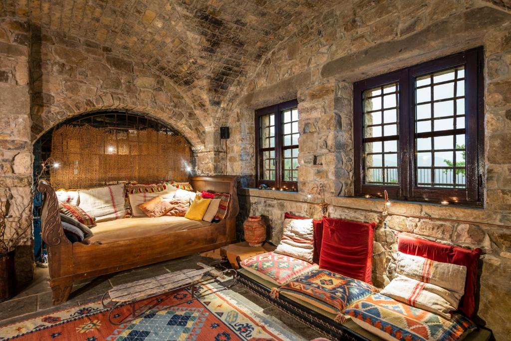 Parrano伊莱弥陀度假酒店的一间卧室配有一张位于石墙内的床铺和一张沙发