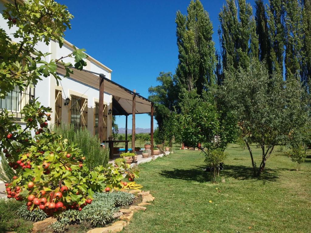 圣拉斐尔Finca La Penúltima-Posada的一座种植了苹果树的花园以及一座建筑