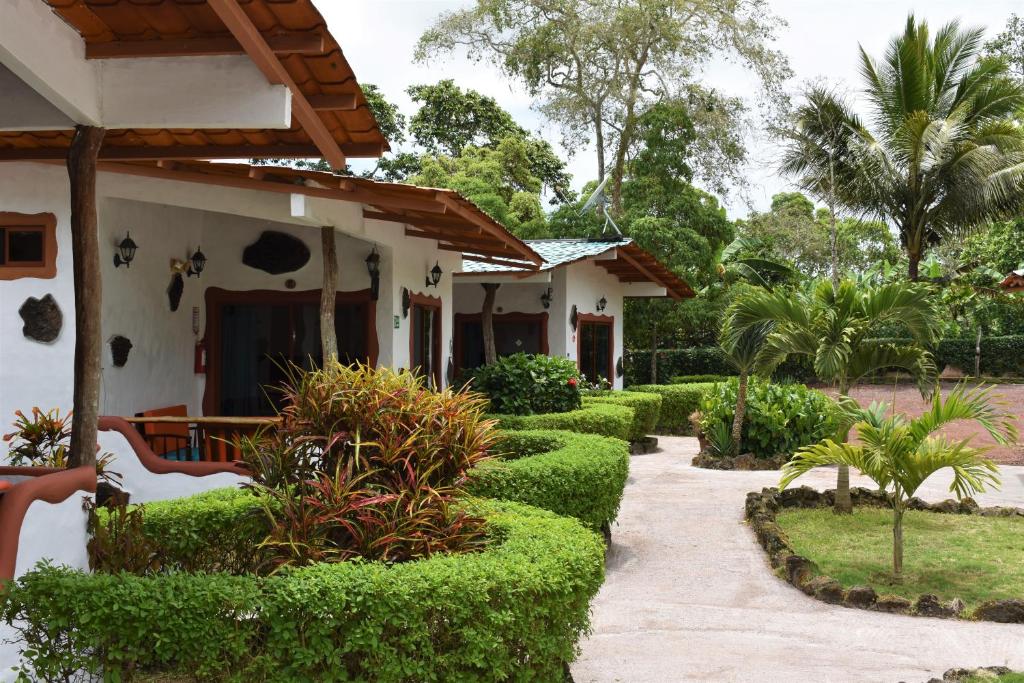 阿约拉港Piedras Blancas Lodge的绿树成荫的房屋前的花园