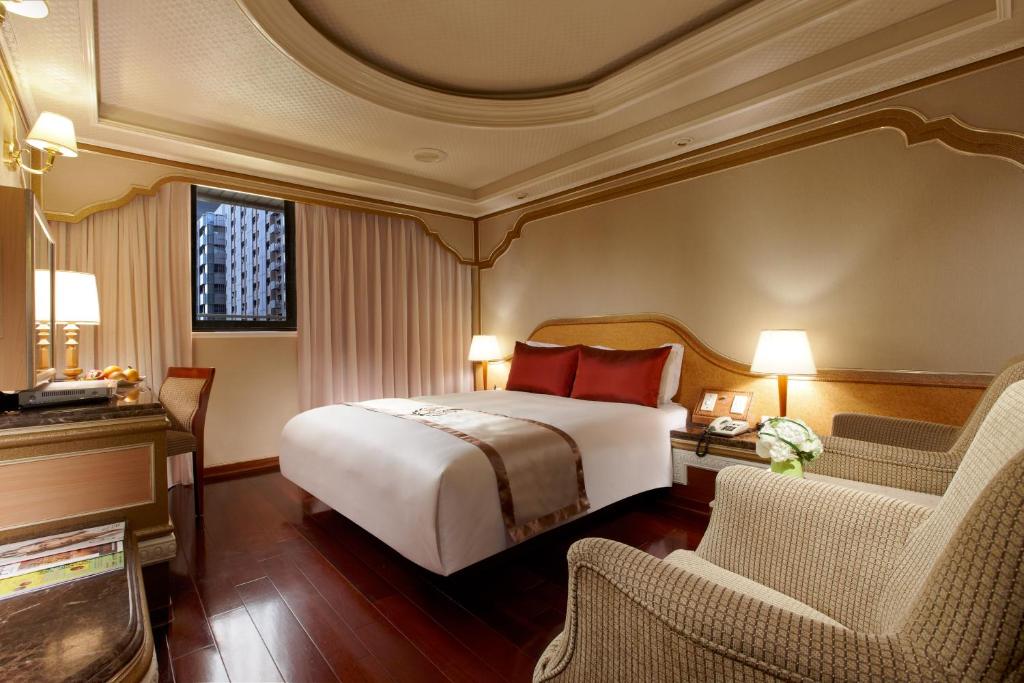台北太豪大饭店的酒店客房,配有一张床和两把椅子