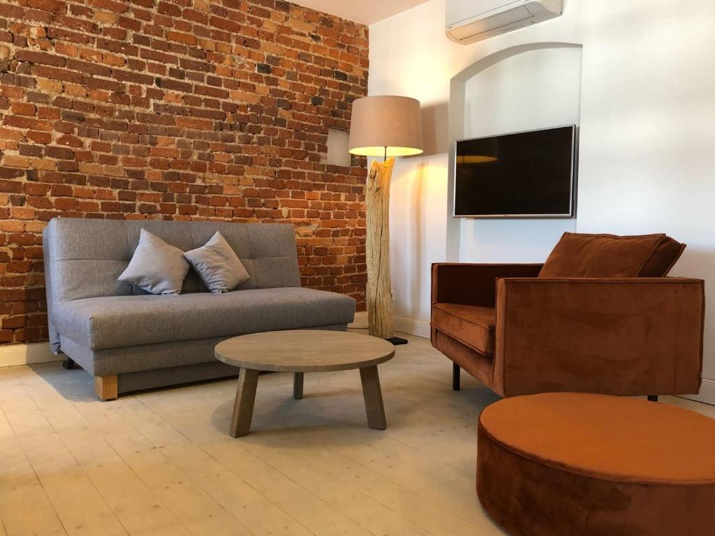 格尔利茨VIA`s Appartements und Ferienwohnungen的客厅配有沙发和椅子