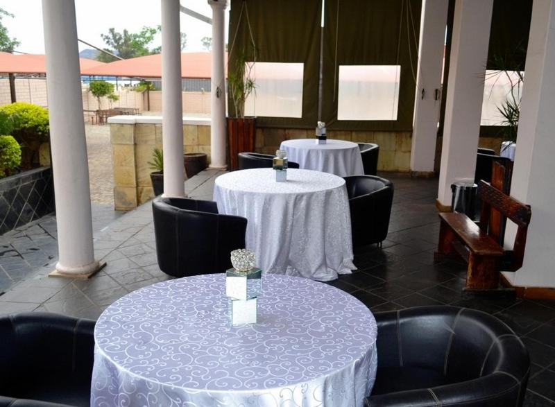 莱迪史密斯Crown Hotel的餐厅内两张带白色桌布的桌子