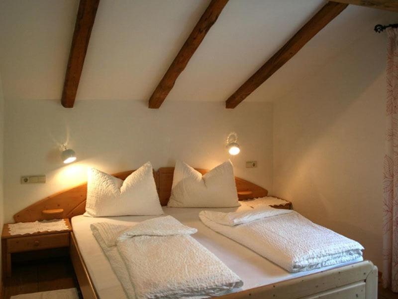蒂鲁罗Garni Streitlhof的一间卧室配有两张带白色枕头的床