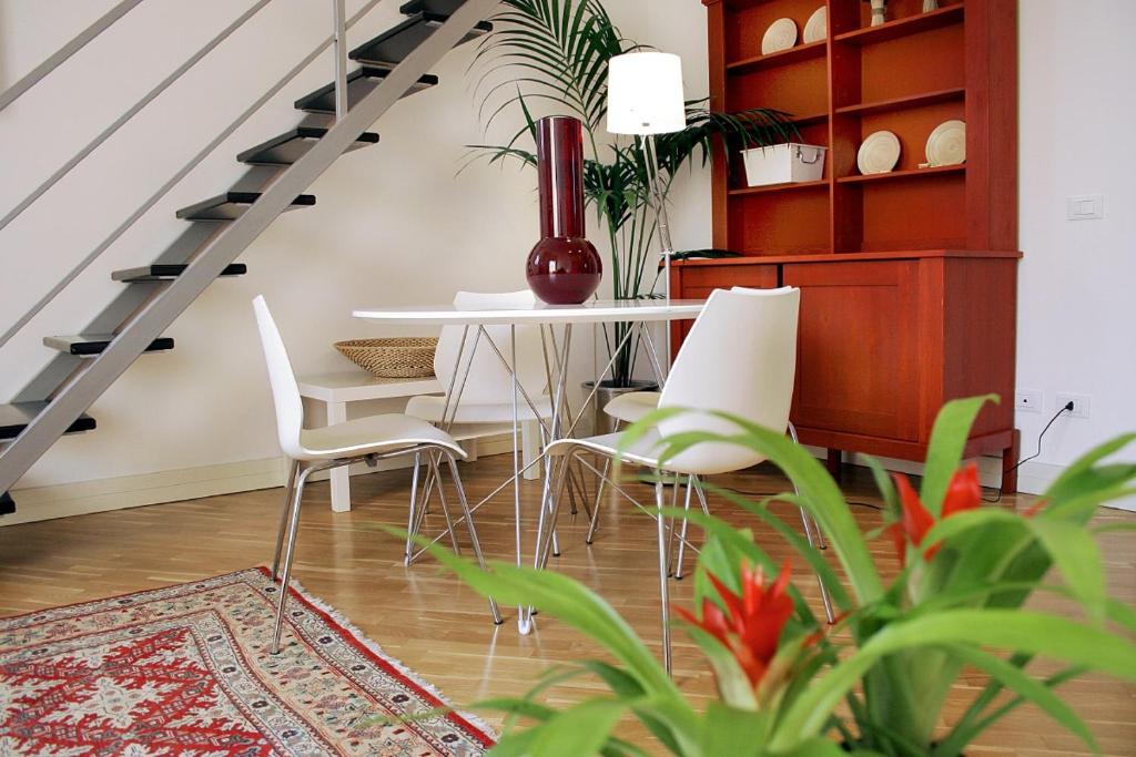 卡塔尼亚Ognina Residence的一间带桌子和白色椅子的用餐室
