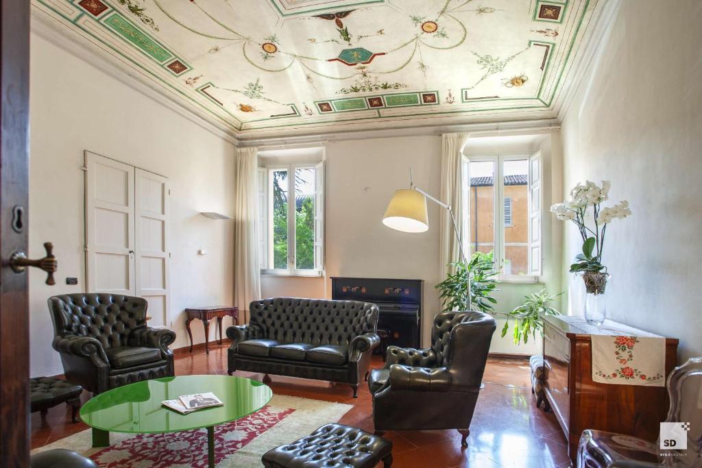 拉文纳Palazzo Galletti Abbiosi的客厅设有椅子、桌子和天花板