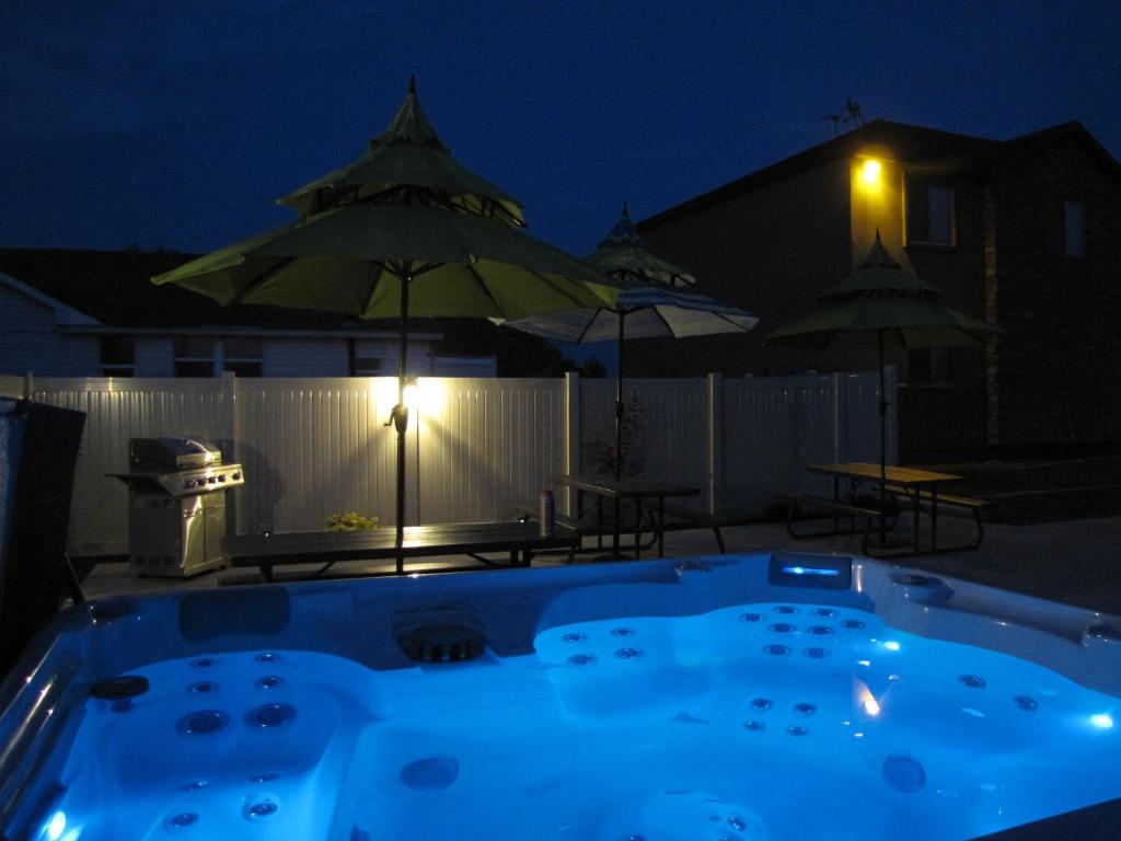 布兰丁Cedar Canyon Condos的游泳池在晚上配有桌子和遮阳伞