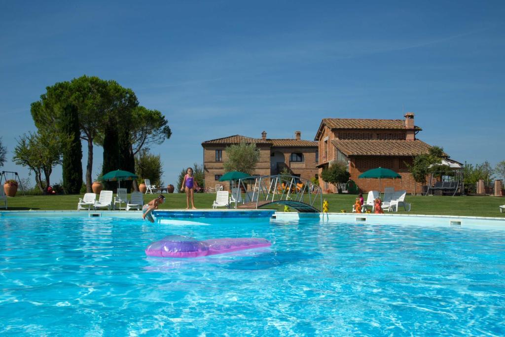 Isola d'Arbia维斯塔乡村别墅的在大型游泳池游泳的人