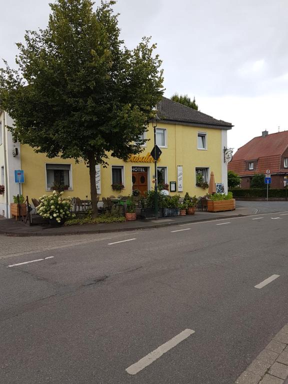 WachtendonkCasalino的街道边有树的黄色房子