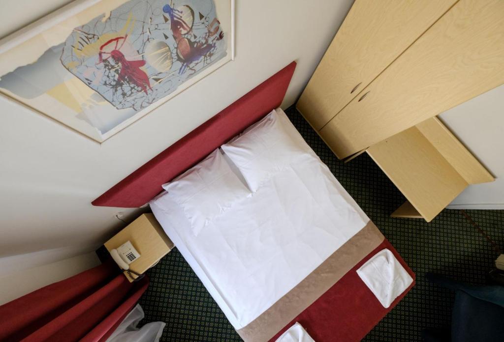考纳斯大都会酒店的小卧室配有一张红色床头板的床