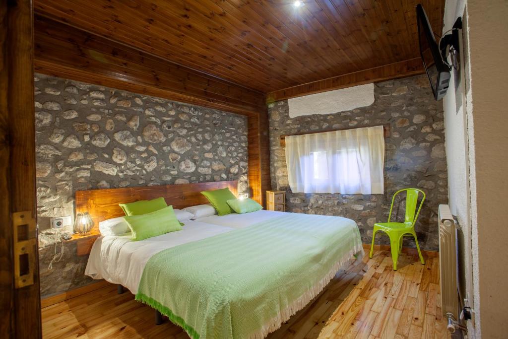 贝尔维尔德赛当亚Hotel Cal Rei de Talló的一间卧室设有一张床和石墙