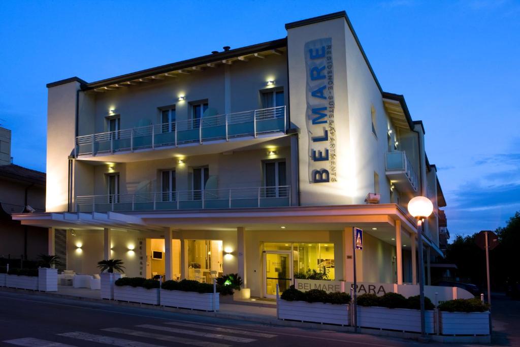 里米尼贝尔马雷住宅酒店的白色的建筑,旁边标有标志