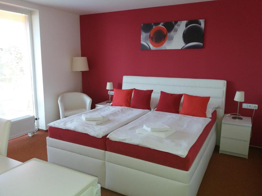 帕索尔维基Vila Moravia的红色卧室配有白色的床和红色枕头