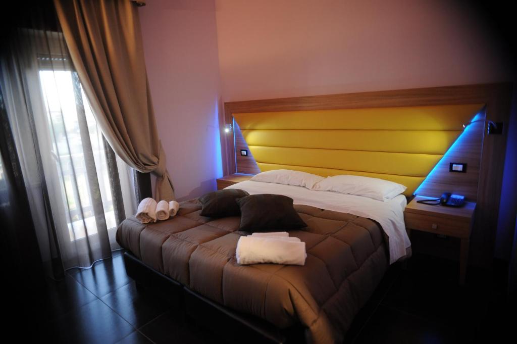 奥斯蒂亚·安提卡奥斯提亚昂提卡套房住宿加早餐酒店的一间卧室配有一张带黄色床头板的大床