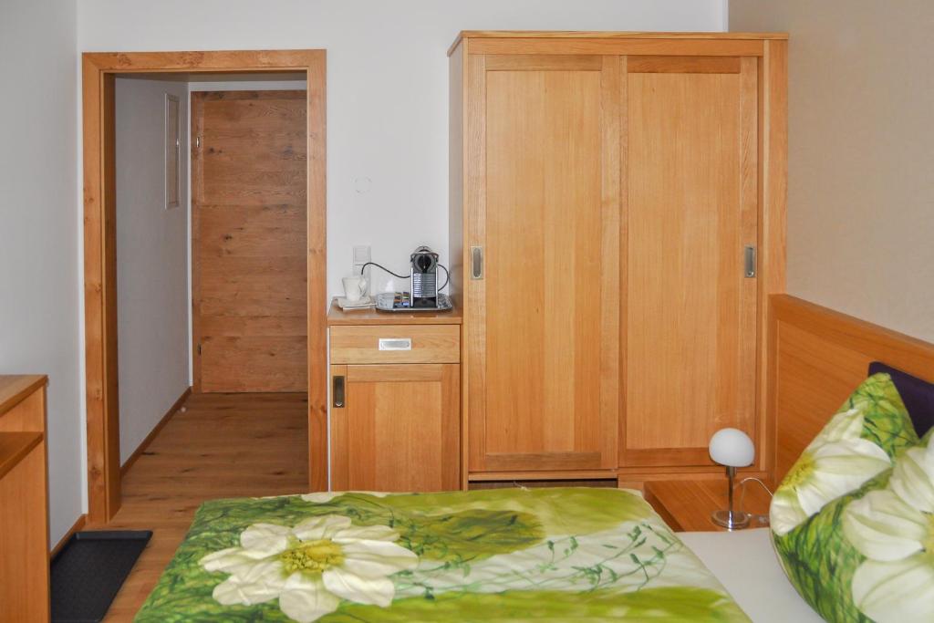 HitzendorfSimandlhof的一间卧室配有一张床和一个木制橱柜