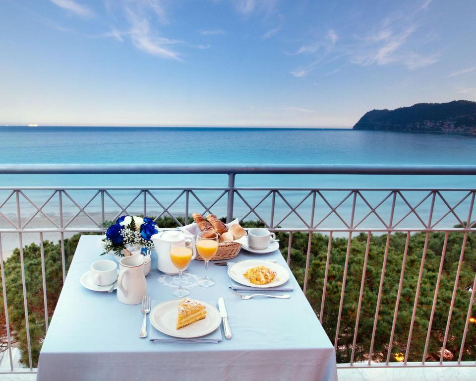 阿拉西奥斯皮亚贾格大酒店的一张桌子,上面摆放着食品和饮料,并享有海景