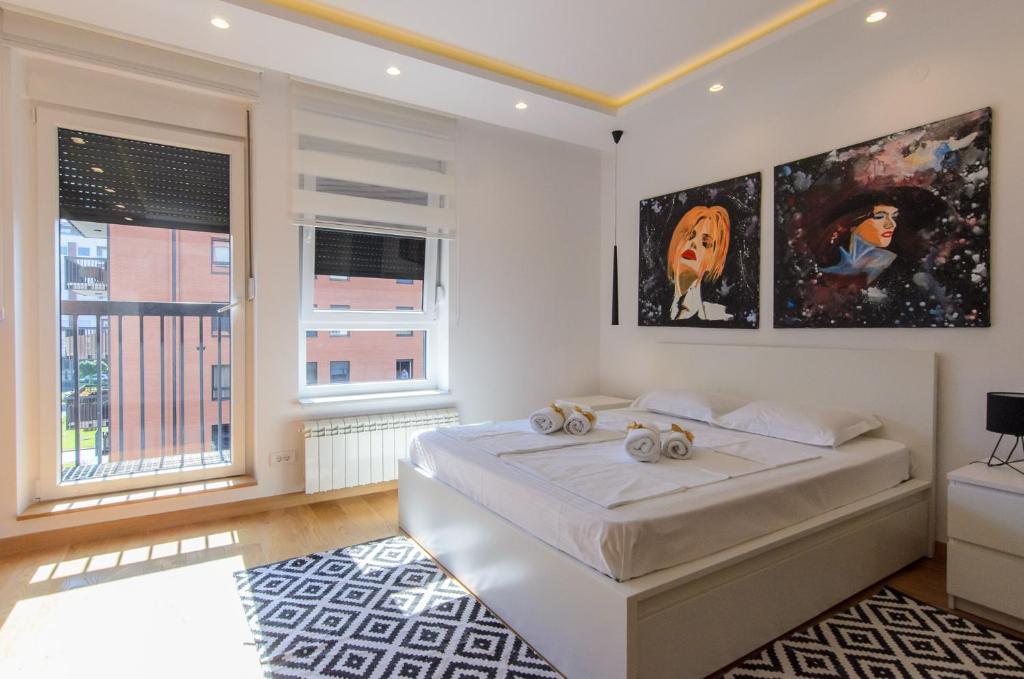 贝尔格莱德Sava Smart Apartment的一间白色卧室,配有床和2个窗户