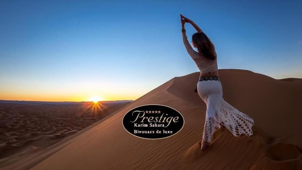 扎古拉Karim Sahara Prestige的站在沙漠沙丘上的女人
