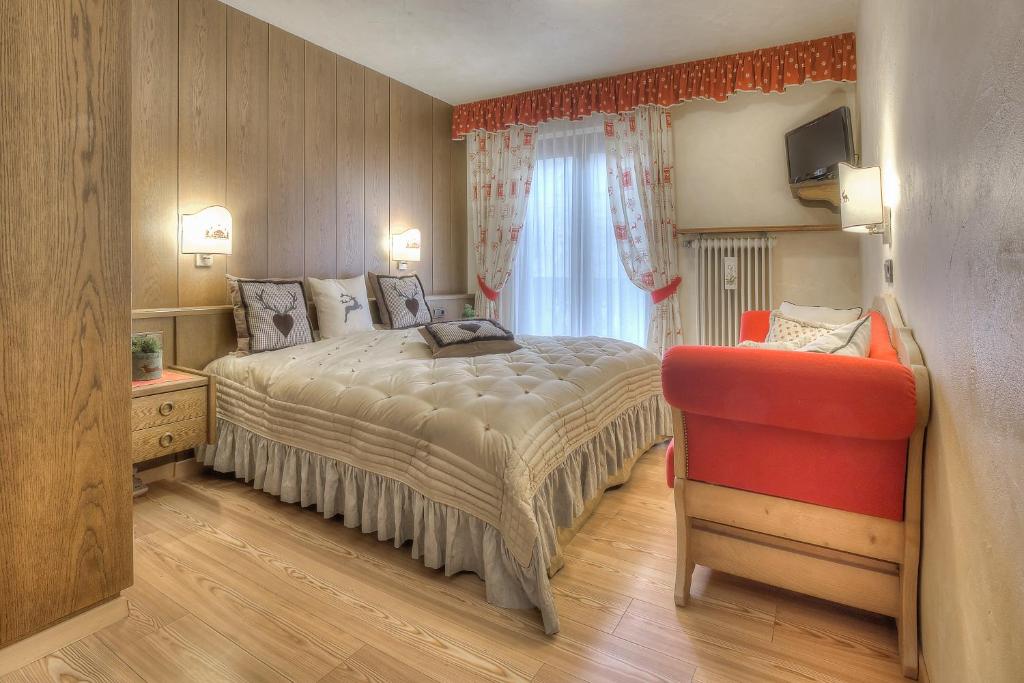 科尔福索Hotel Luianta的一间卧室配有一张床和一张红色椅子