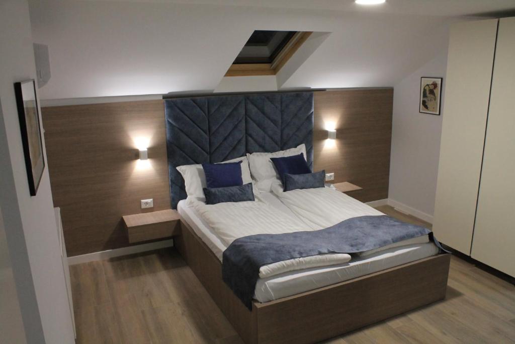 普里什蒂纳Sleep Inn Prishtina的一间卧室配有一张带蓝色枕头的大床