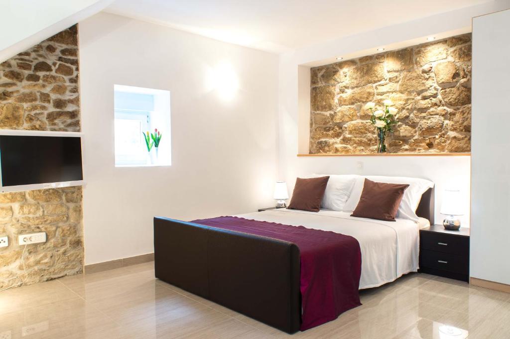 斯普利特斯普利特倾城公寓的一间卧室设有一张大床和石墙