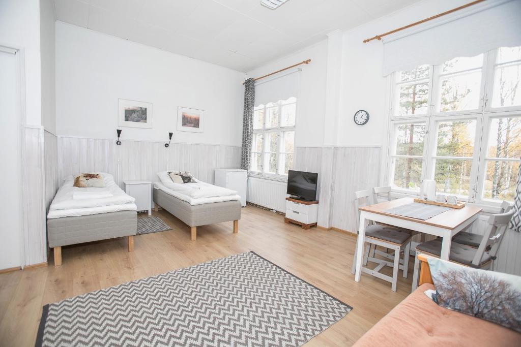 Ahmovaara科里闲暇时光旅馆的白色的客厅配有桌子和沙发