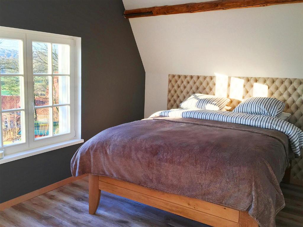 绍蒙－吉斯图Wengé Lodge的一间卧室设有一张床和两个窗户。