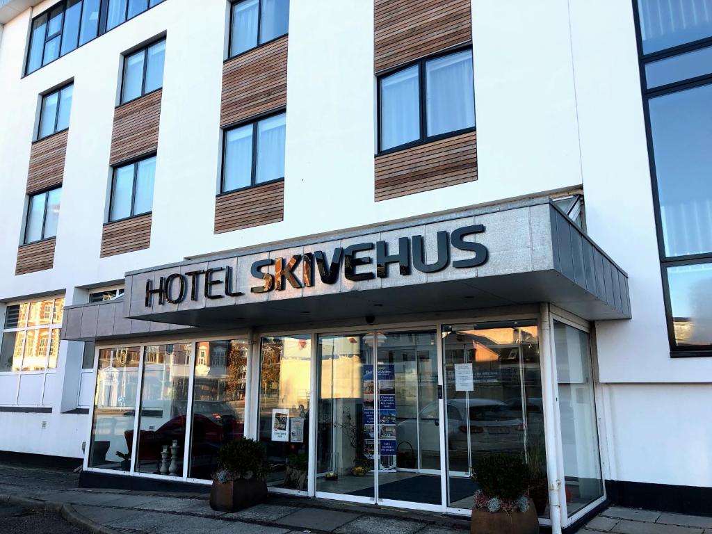 斯基沃Hotel Skivehus的大楼前方的酒店标志