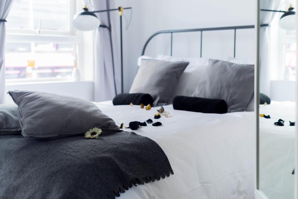 贝尔法斯特Amica Guesthouse的白色的床,上面有灰色的枕头和鲜花