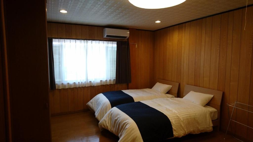 桑名市Minpaku Nagashima room2 / Vacation STAY 1036的一间卧室设有一张床和一个窗口