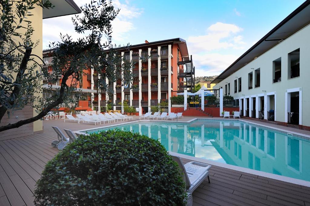 托尔博莱拉维拉俱乐部酒店e公寓的一座带椅子的建筑和一座大楼内的游泳池