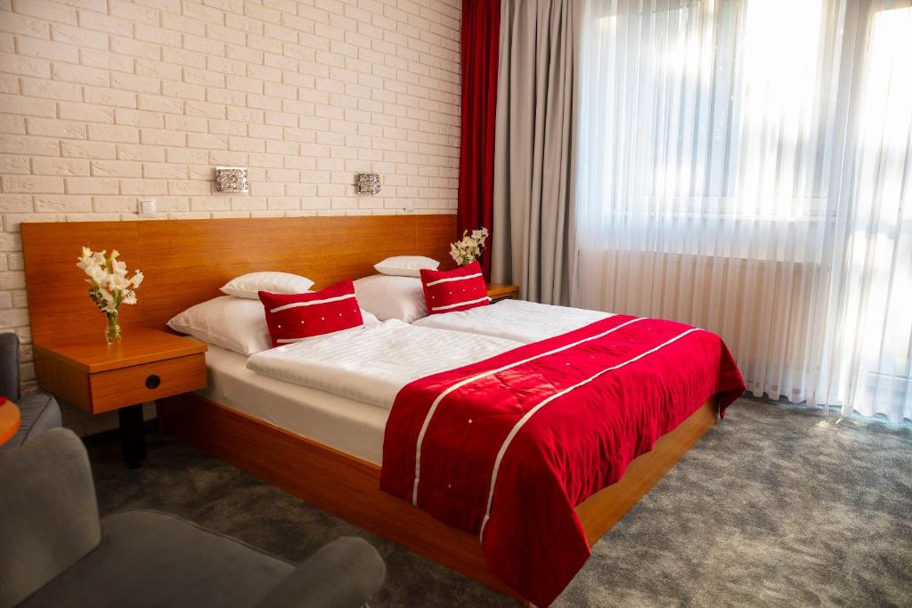 StęszewMotel 2000的一间卧室配有一张带红色枕头的大床