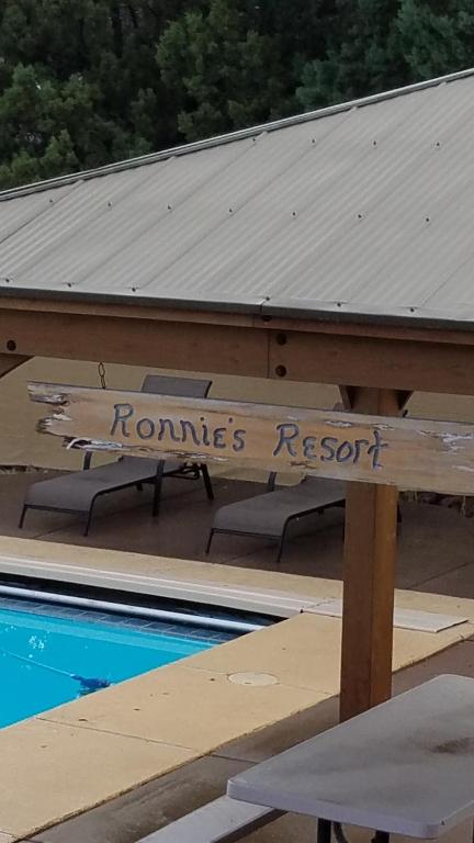 佩森Ronnie's Resort的游泳池旁的标志,上面写着罗姆斯度假村的标志