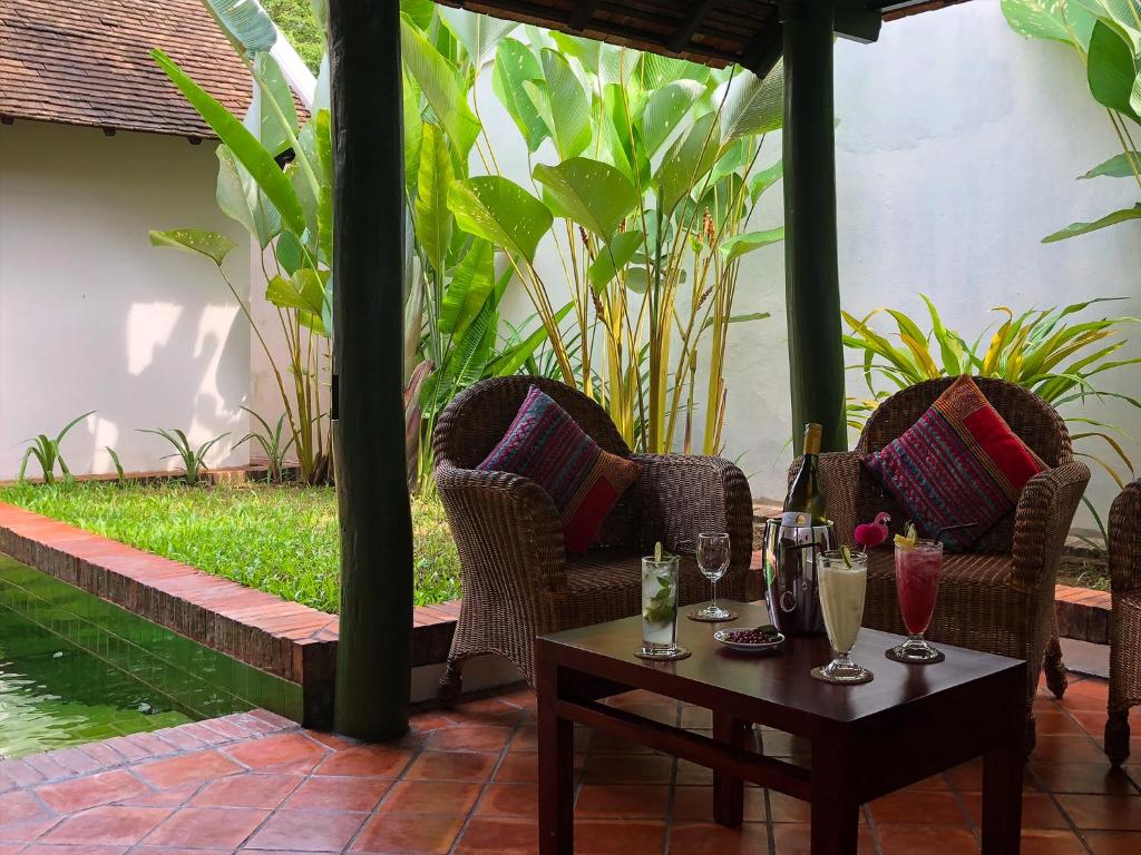 琅勃拉邦Maison Houng Chanh - Luang prabang的庭院配有椅子和桌子及玻璃杯
