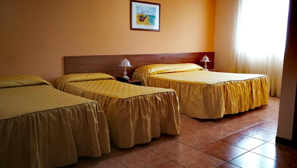 莫塔·圣塔纳斯塔西亚瓦莱德优利维酒店的酒店客房的三张床,配有金色床单