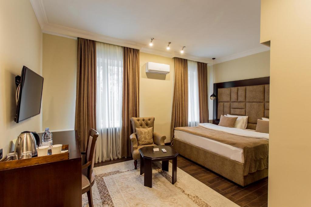 阿拉木图大使酒店的配有一张床和一把椅子的酒店客房