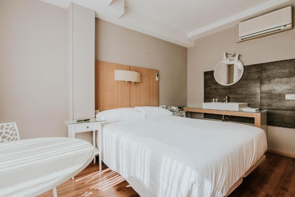 洛格罗尼奥Hotel Isasa的白色卧室设有两张床和水槽