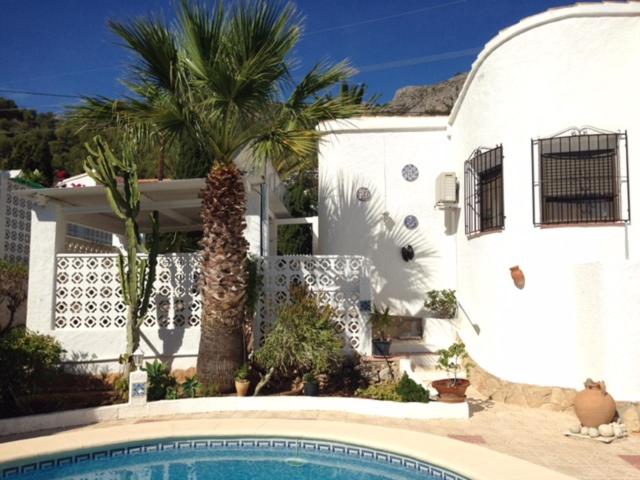 卡尔佩Karibuni的一座白色的房子,设有游泳池和棕榈树